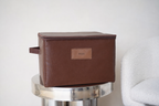 CUBBLI keepsake box in Chocolate brown, closed, on a marble side table