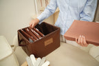 Woman filing a folder into an open CUBBLI Chocolate keepsake box