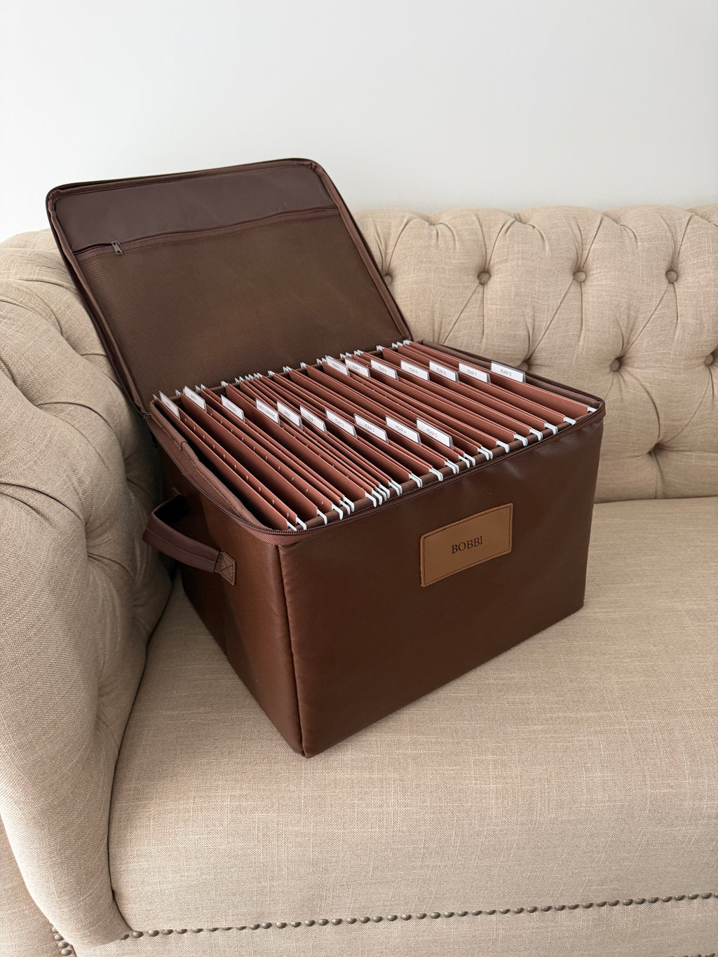Open CUBBLI Chocolate keepsake box full of labelled folders, on a sofa