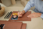 Hand signing a child's photo card with the CUBBLI Heritage pen