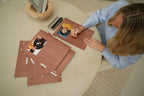 Overhead view of a woman arranging CUBBLI folders and photo cards on a table