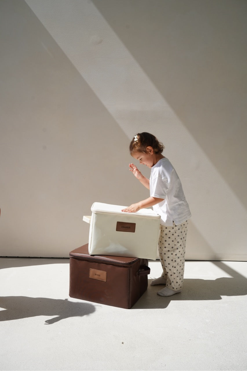Child reaching into an open CUBBLI Cream keepsake box in sunlight