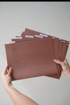 Hands holding a fanned stack of CUBBLI keepsake file folders